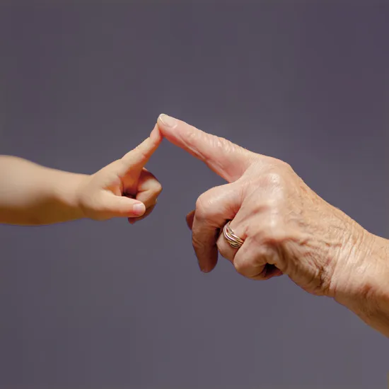 Die Fingerspitzen des Zeigefingers eines Kindes und einer erwachsenen Person berühren sich sanft. 