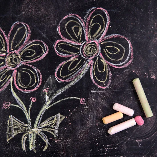 Auf einem dunklen Hintergrund ist mit bunter Kreide ein Blumenstrauss gemalt.